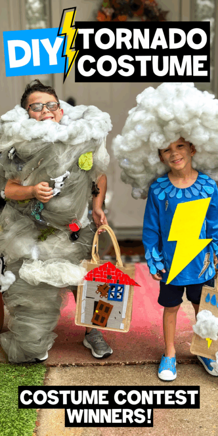 Two kids dressed as a tornado and a storm cloud, holding handmade prop houses, celebrating their DIY costumes.