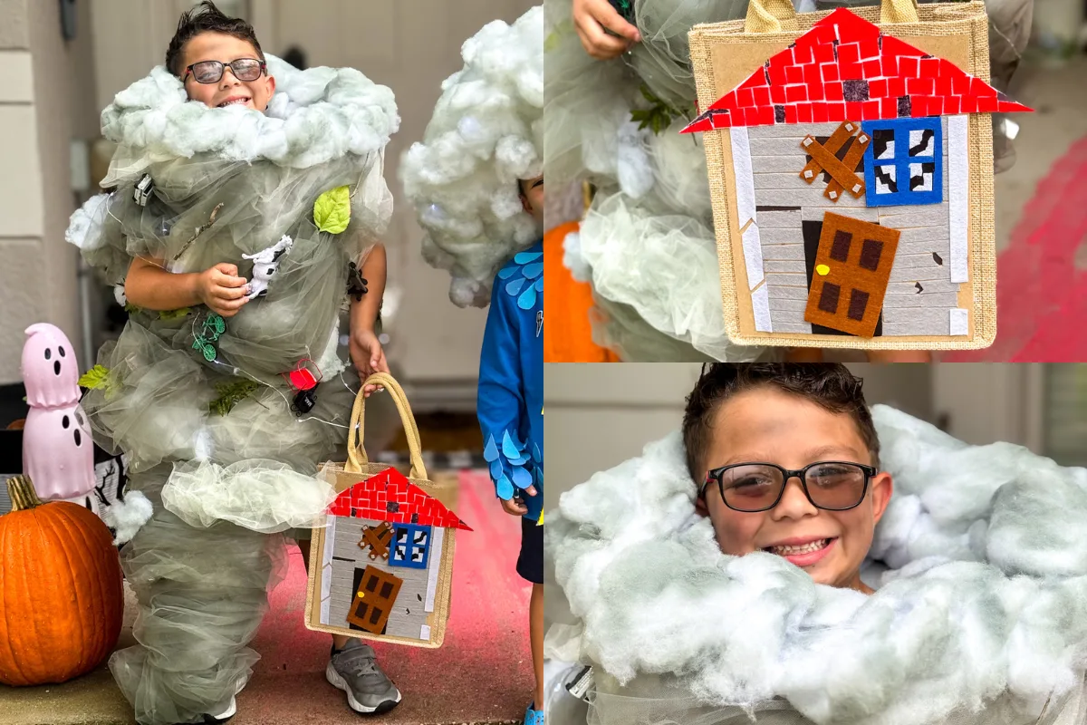 A child wearing a tornado-themed costume with toy animals and fake clouds, holding a basket decorated with a fabric house, stands near a pumpkin and Halloween decorations.
